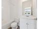 Well-lit bathroom with white cabinets, toilet, and a shower-tub combo at 6850 Merseyside Ln, Castle Pines, CO 80108