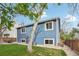 Picture of a blue house with a side yard with mature trees, a patio table, and a wooden fence for privacy at 7061 Palisade Dr, Highlands Ranch, CO 80130