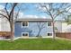 Blue house with a lush green yard and patio set with chairs, framed by mature trees, offering a serene outdoor space at 7061 Palisade Dr, Highlands Ranch, CO 80130