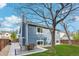 Landscaped backyard with patio, outdoor seating, mature tree, and partial view of the home's exterior at 7061 Palisade Dr, Highlands Ranch, CO 80130