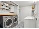 Well-lit bathroom featuring patterned tile floor, modern vanity, glass shower, and a laundry area at 7061 Palisade Dr, Highlands Ranch, CO 80130