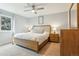 Cozy bedroom with a wood-frame bed, neutral colors, ceiling fan, and ample natural light at 7061 Palisade Dr, Highlands Ranch, CO 80130