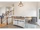 Staircase and white island in entryway under a chandelier with wood accents at 7061 Palisade Dr, Highlands Ranch, CO 80130