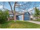 Charming blue home featuring a well-manicured lawn, brick accents, and a two-car garage at 7061 Palisade Dr, Highlands Ranch, CO 80130