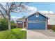 Charming blue home featuring a well-manicured lawn, brick accents, and a two-car garage at 7061 Palisade Dr, Highlands Ranch, CO 80130