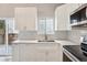 Bright kitchen with white cabinets, stainless appliances, mosaic backsplash, and access to the backyard at 7061 Palisade Dr, Highlands Ranch, CO 80130