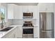A well-lit kitchen with white cabinets, stainless steel appliances, and mosaic backsplash at 7061 Palisade Dr, Highlands Ranch, CO 80130