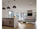 Open-concept living space with hardwood floors, stone fireplace, kitchen, and large windows with picturesque views at 680 Lone Eagle Dr, Granby, CO 80015
