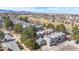 Aerial view of gray townhomes with a golf course and a mountain range in the background on a sunny day at 6725 W 84Th Way # 67, Arvada, CO 80003