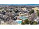 An aerial view of townhomes, a pool covered for the winter, and tennis courts in a community at 6725 W 84Th Way # 67, Arvada, CO 80003