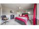 Relaxing bedroom showcasing a TV, dresser, and a bed bathed in natural light from a window with red curtains at 6725 W 84Th Way # 67, Arvada, CO 80003