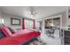 Bright bedroom with modern ceiling fan, built-in shelving and desk next to a large window with red curtains at 6725 W 84Th Way # 67, Arvada, CO 80003