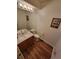 A clean and modern bathroom featuring a wooden vanity, toilet, and wood-look floors, creating a cozy ambiance at 2619 S Iris Ct, Lakewood, CO 80227