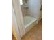Clean bathroom with white tiled walls, tub with shower, and beige flooring at 2619 S Iris Ct, Lakewood, CO 80227