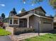 Charming two-story brick home featuring a well-manicured lawn, attached two-car garage, and classic architectural details at 2619 S Iris Ct, Lakewood, CO 80227