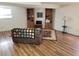 Inviting living room with hardwood floors, a comfortable sofa, and built-in bookshelves, creating a cozy atmosphere at 2619 S Iris Ct, Lakewood, CO 80227
