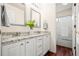 Bathroom featuring dual sinks with granite countertops, white cabinetry and updated fixtures at 132 Mesa St, Brighton, CO 80601