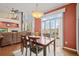 Cozy dining area with wooden table near a fireplace and abundant natural light offers comfort and elegance at 132 Mesa St, Brighton, CO 80601