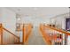 Second floor hallway provides access to the bedrooms with wood railing at 132 Mesa St, Brighton, CO 80601