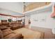 Open living room features a cathedral ceiling and adjoins kitchen with hardwood flooring at 132 Mesa St, Brighton, CO 80601