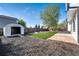 Backyard featuring artificial turf, mulch beds, stone accents, a storage shed, and a concrete patio at 12018 Hudson Ct, Thornton, CO 80241