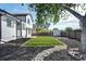 Landscaped backyard featuring artificial turf, stone accents, mulch beds, and a storage shed at 12018 Hudson Ct, Thornton, CO 80241