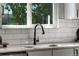 Modern kitchen sink with black faucet, marble countertops and subway tile backsplash at 12018 Hudson Ct, Thornton, CO 80241