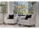 Cozy sitting area with two chairs beside a large window with tree view at 12018 Hudson Ct, Thornton, CO 80241
