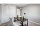 Modern office space features a dark wood desk, white chair, and double door closet at 12018 Hudson Ct, Thornton, CO 80241