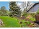 Spacious backyard featuring a well-maintained lawn, mature trees, and garden beds for gardening enthusiasts at 1118 Eagle Rd, Broomfield, CO 80020
