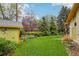 Expansive backyard with a lush lawn, mature trees, and a charming garden shed and green exterior at 1118 Eagle Rd, Broomfield, CO 80020