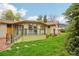 Beautiful backyard with a modern deck, lush lawn, and mature trees for outdoor living and entertainment at 1118 Eagle Rd, Broomfield, CO 80020