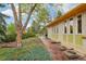 Charming single-story home showcasing a white brick exterior and natural landscaping along a stone walkway at 1118 Eagle Rd, Broomfield, CO 80020