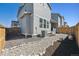A gravel path runs along the backyard of this gray home surrounded by a wooden fence at 700 Lillibrook Pl, Erie, CO 80026