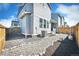 Backyard view showcasing gravel landscaping, AC unit, fence and neighboring homes in a well-maintained community at 700 Lillibrook Pl, Erie, CO 80026