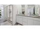 Bright bathroom features double sinks, white cabinets, and a glass-enclosed shower at 700 Lillibrook Pl, Erie, CO 80026