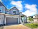 Charming two-story home featuring a gray exterior, brick driveway, and attached garage at 700 Lillibrook Pl, Erie, CO 80026