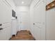 Hallway with wood floors, white doors, white trim, and coat rack at 700 Lillibrook Pl, Erie, CO 80026