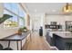 Bright, open kitchen featuring modern appliances, white cabinetry, an island and wood floors at 700 Lillibrook Pl, Erie, CO 80026