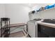 A bright laundry room with modern appliances, a folding table, and ample storage at 700 Lillibrook Pl, Erie, CO 80026