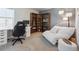 Well-lit home office features a desk, comfortable seating, and custom built-in bookshelves at 700 Lillibrook Pl, Erie, CO 80026