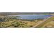 Community aerial view featuring a calm lake with beach access and city skyline in the distance at 13894 E Lehigh Ave # G, Aurora, CO 80014