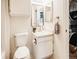 All white bathroom with a modern vanity, stacked washer dryer and matching mirrored medicine cabinets at 13894 E Lehigh Ave # G, Aurora, CO 80014