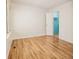 A bedroom featuring wood flooring, a bright window, and an open closet with natural light at 13894 E Lehigh Ave # G, Aurora, CO 80014