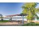 Community picnic area features covered tables and serene lake views on a bright, sunny day at 13894 E Lehigh Ave # G, Aurora, CO 80014