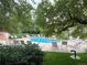 Community pool surrounded by lounging chairs, trees and green grass at 13894 E Lehigh Ave # G, Aurora, CO 80014
