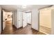 Hallway view with hardwood floors, white walls, laundry room, and a doorway to another room with a modern art piece at 1157 N Downing St, Denver, CO 80218