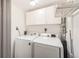 Laundry room featuring newer side-by-side washer and dryer, white cabinets, and a wire shelf at 1157 N Downing St, Denver, CO 80218