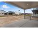 View of the backyard from covered patio, showing a flag and neighbor homes at 3432 N Gold Bug Ct, Aurora, CO 80019