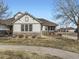 A charming single story house with a cozy porch, stone accents, and a well-manicured lawn at 7890 S Quatar, Aurora, CO 80016